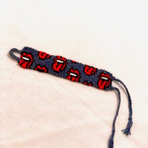 Handmade macramé bracelet with repeating red lips design on a dark background and braided adjustable ties.