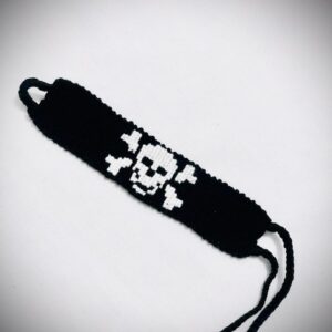 Handmade black macramé bracelet featuring a white skull and crossbones design with braided adjustable ties