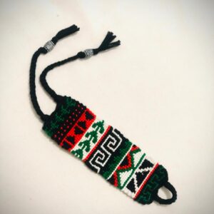 Handmade macramé bracelet with red, black, green, and white tribal-inspired geometric patterns, braided ties, and silver accent beads.