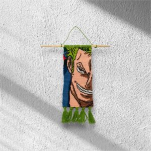 Handwoven macramé wall hanging inspired by Zoro from One Piece, featuring his green hair, confident grin, and green tassel finish
